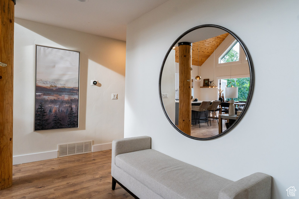 Corridor featuring wood finished floors and vaulted ceiling