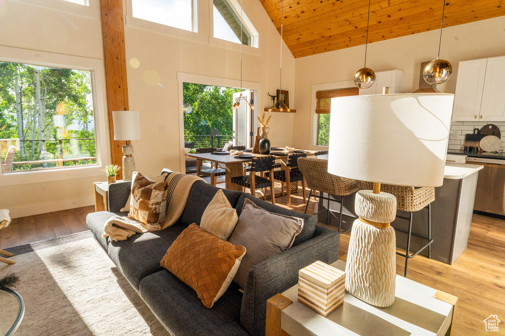 Living area with plenty of natural light, light wood-style floors, high vaulted ceiling, and wood ceiling