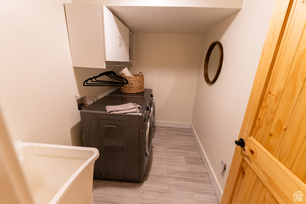 Laundry room with washer and clothes dryer and baseboards