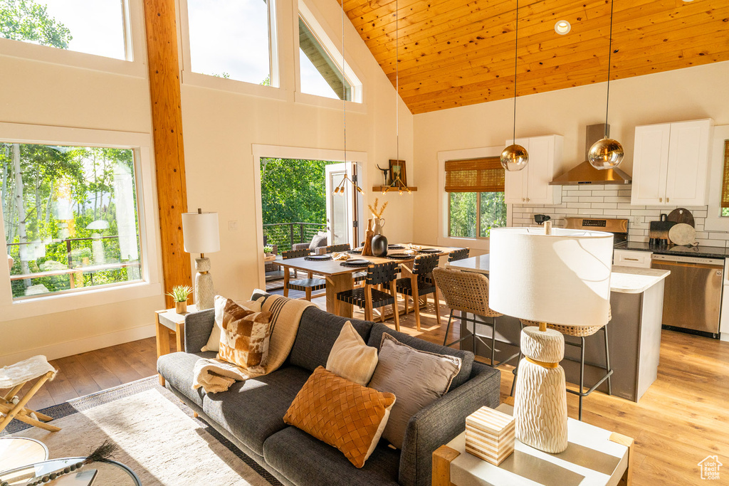 Living room with high vaulted ceiling and light wood-style floors