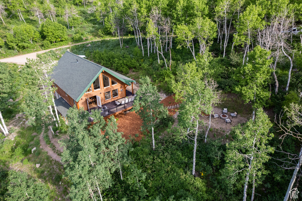Aerial view of property and surrounding area featuring a forest