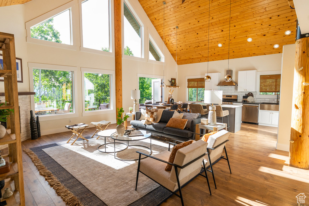 Living room featuring high vaulted ceiling, plenty of natural light, light wood-style flooring, and wood ceiling