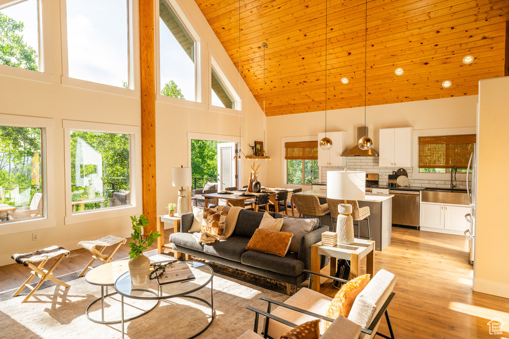 Living area with high vaulted ceiling, light wood finished floors, and wood ceiling