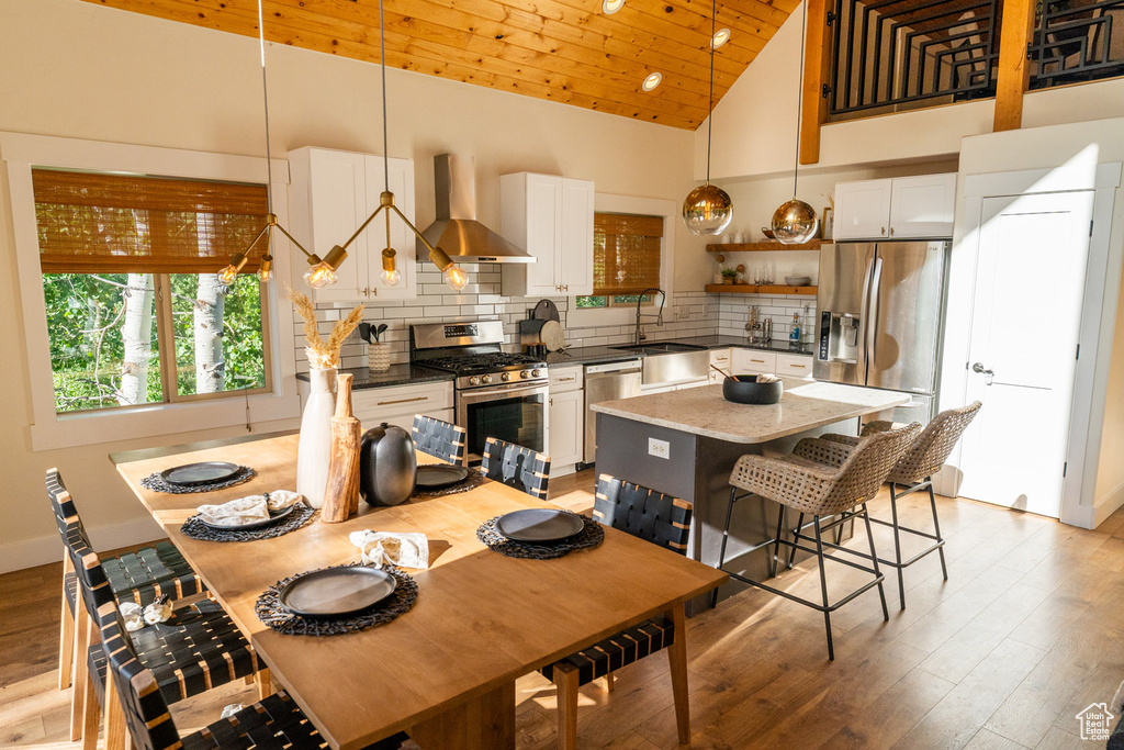 Dining area featuring light wood-style floors and high vaulted ceiling
