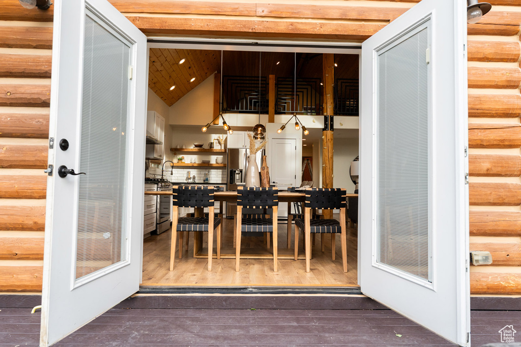 Dining space with wood finished floors and high vaulted ceiling