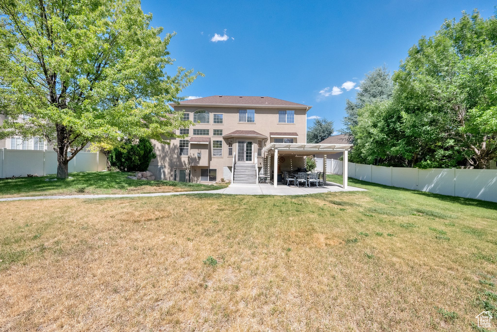 Back of property with a patio area, stucco siding, and a fenced backyard