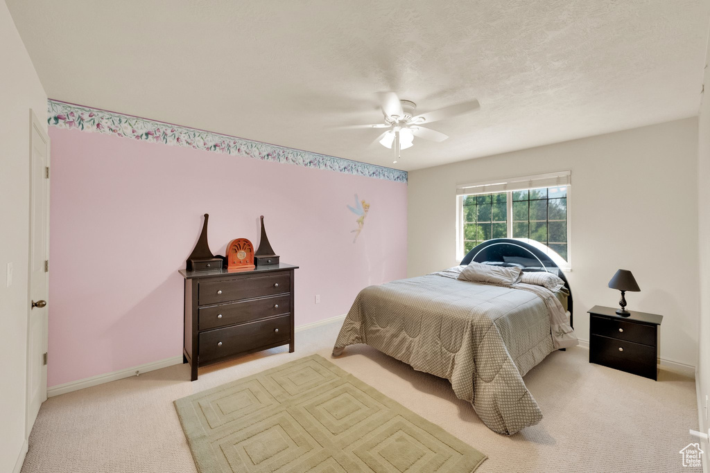 Carpeted bedroom featuring baseboards and ceiling fan