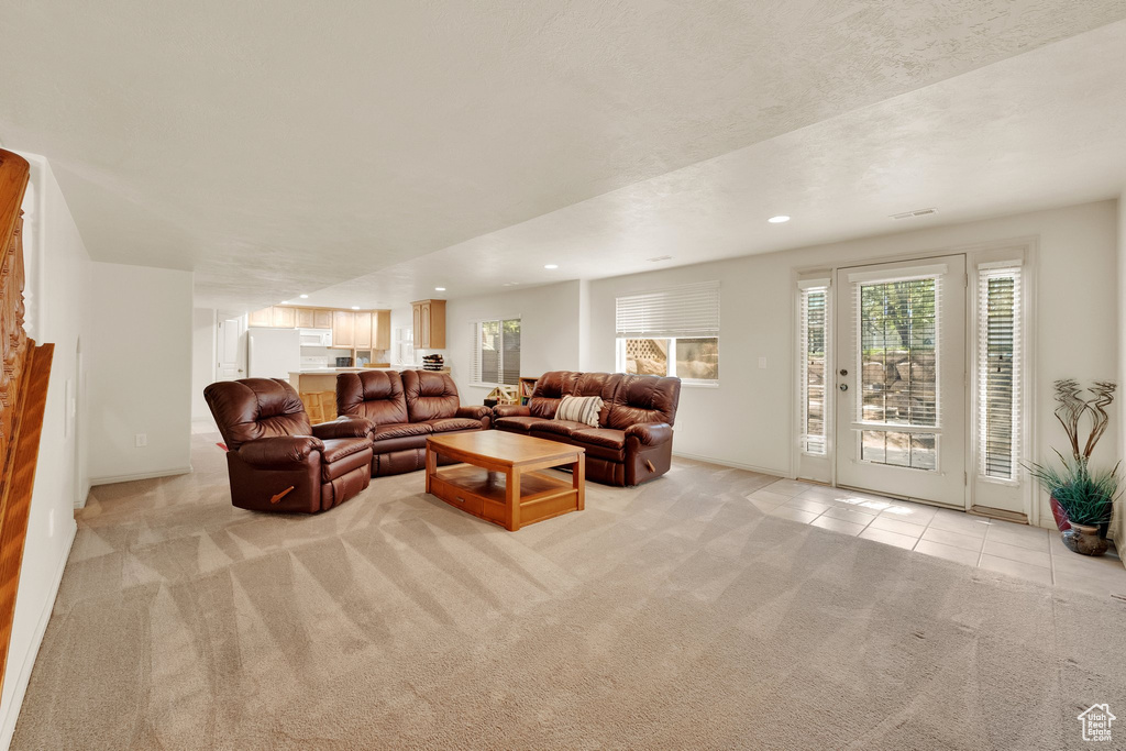 Living room with light colored carpet, plenty of natural light, and recessed lighting