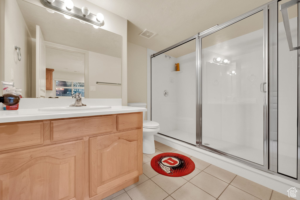 Full bathroom featuring tile patterned flooring, a stall shower, and vanity