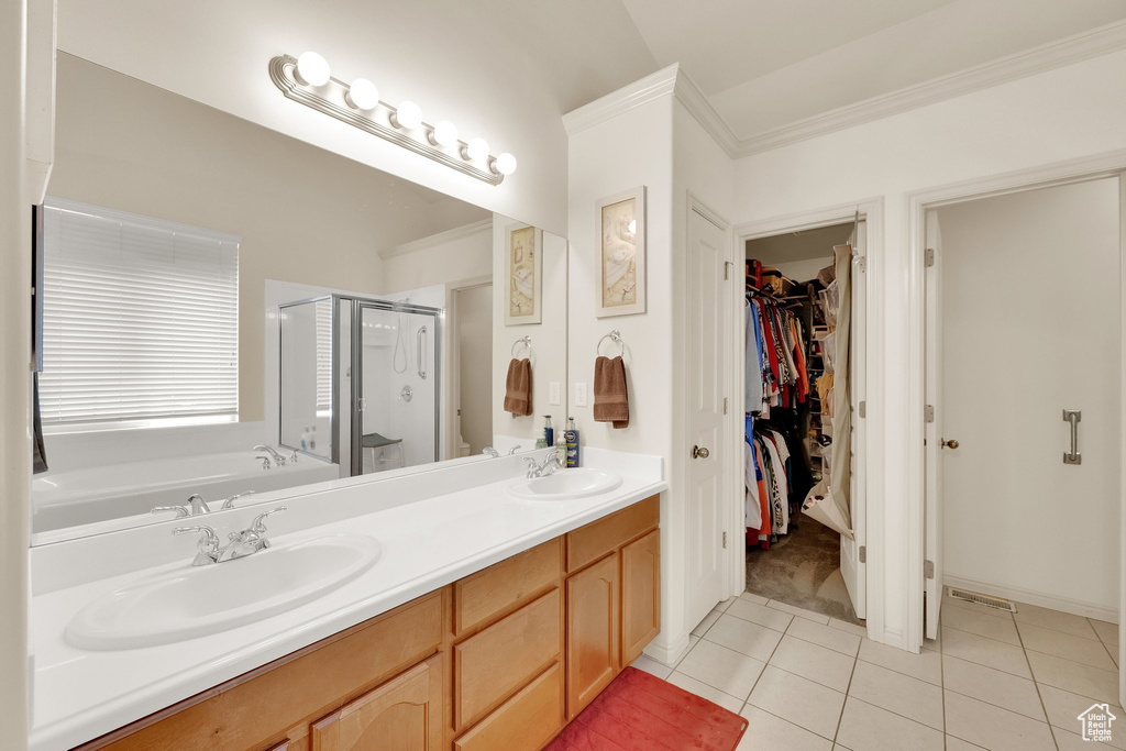 Full bath with a shower stall, tile patterned floors, a walk in closet, a garden tub, and double vanity