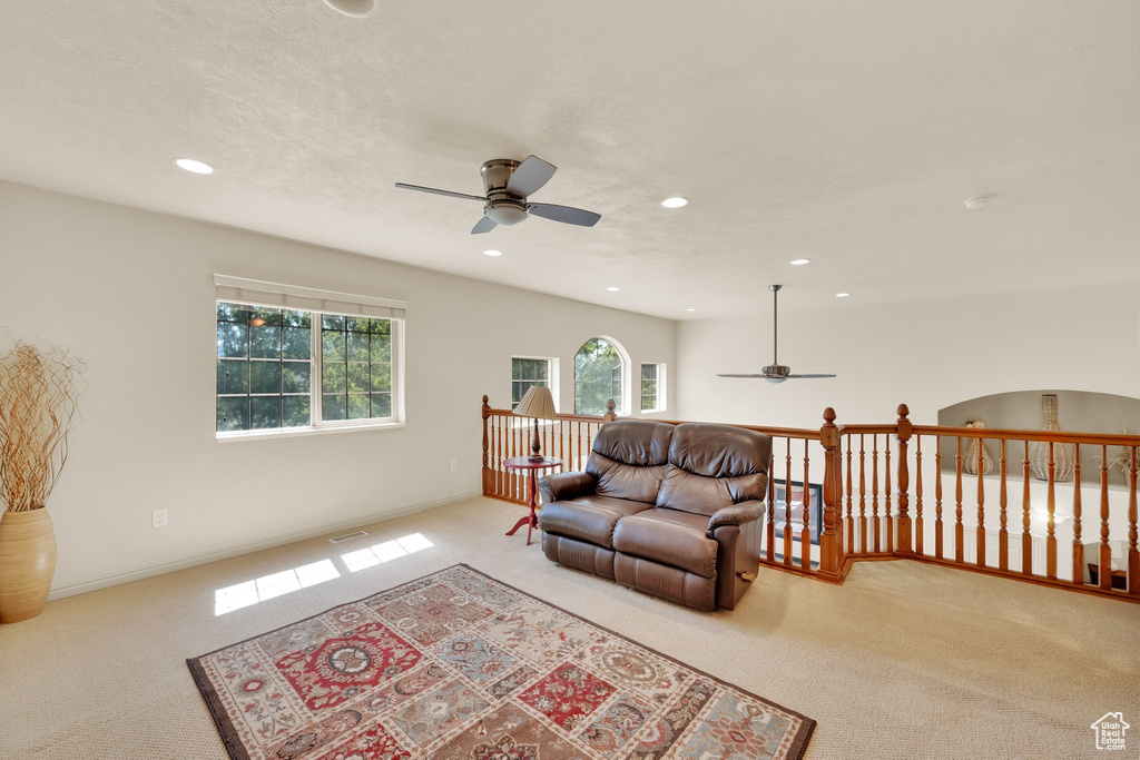 Carpeted living room featuring ceiling fan and recessed lighting