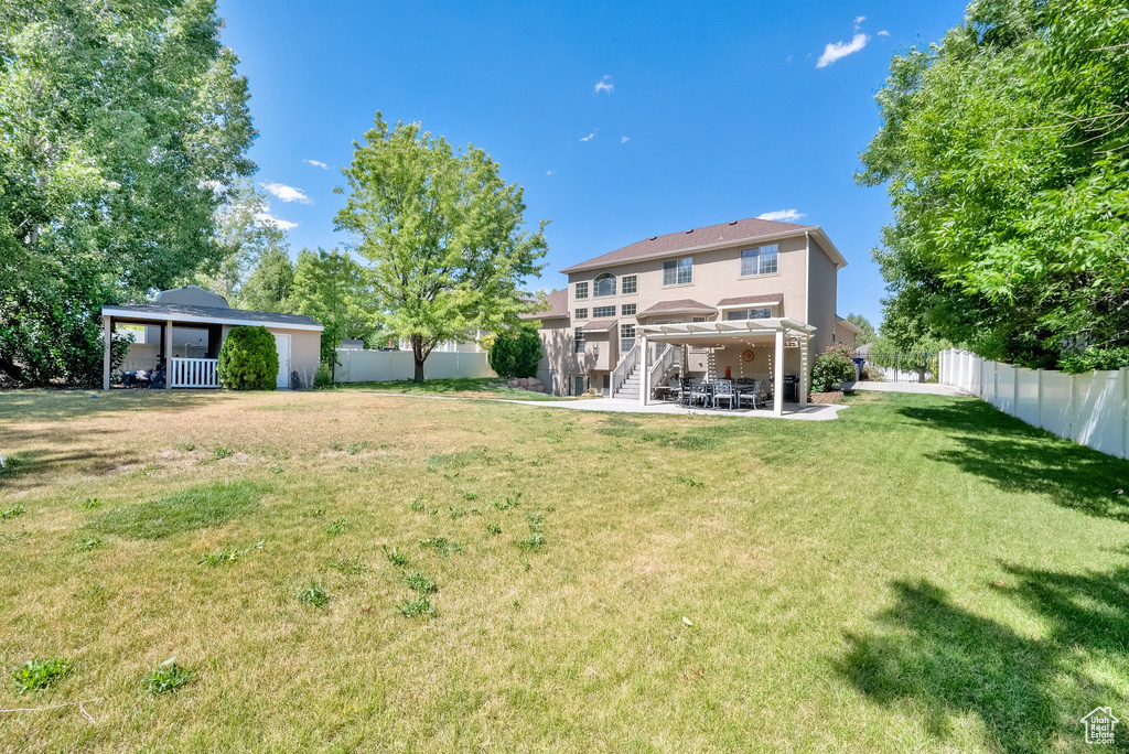 Rear view of property featuring a fenced backyard and a patio
