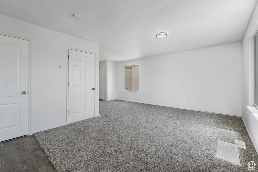 Empty room featuring a smoke detector and carpet