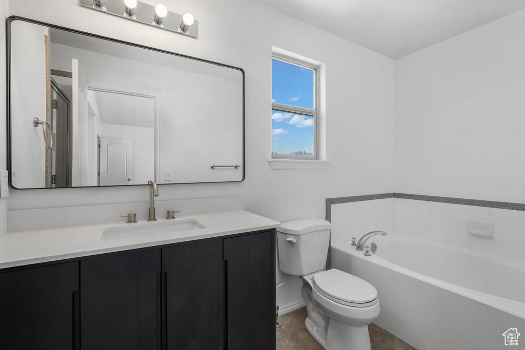 Full bath featuring a bath, vanity, and tile patterned flooring