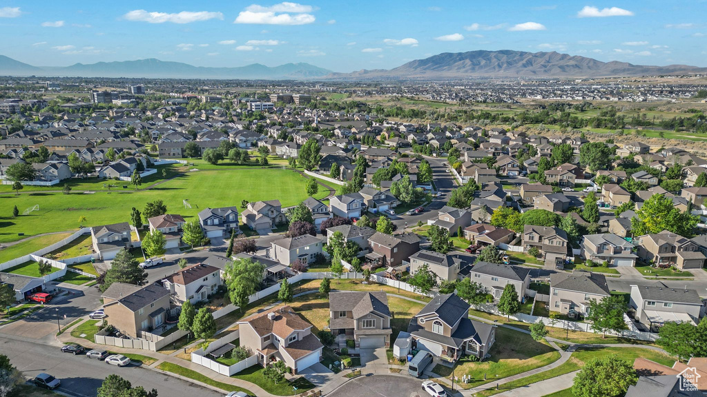 Aerial view of property and surrounding area with a mountainous background and nearby suburban area