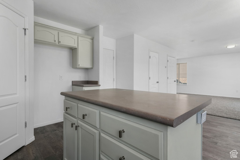 Kitchen with dark countertops, open floor plan, dark wood-style floors, and a kitchen island