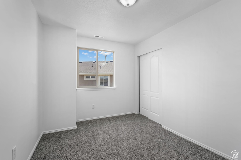 Carpeted empty room with baseboards