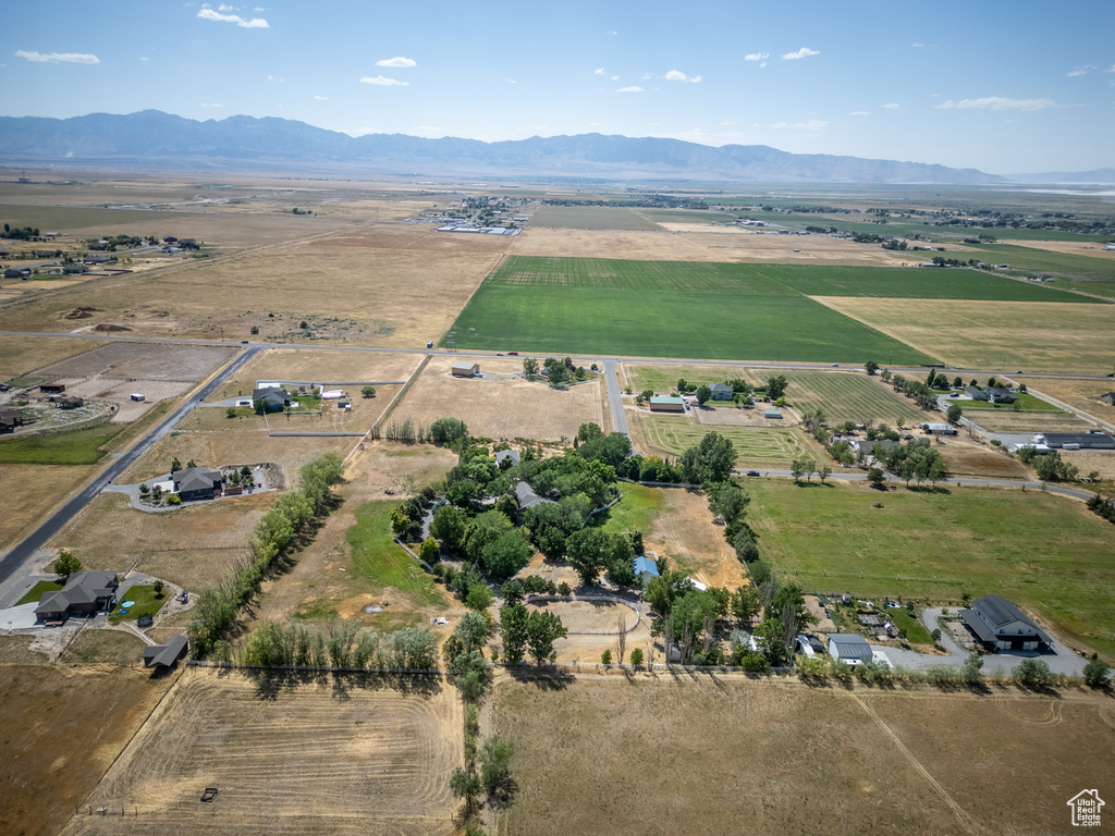 Aerial view of property's location featuring rural landscape, mountains, and rows of crops