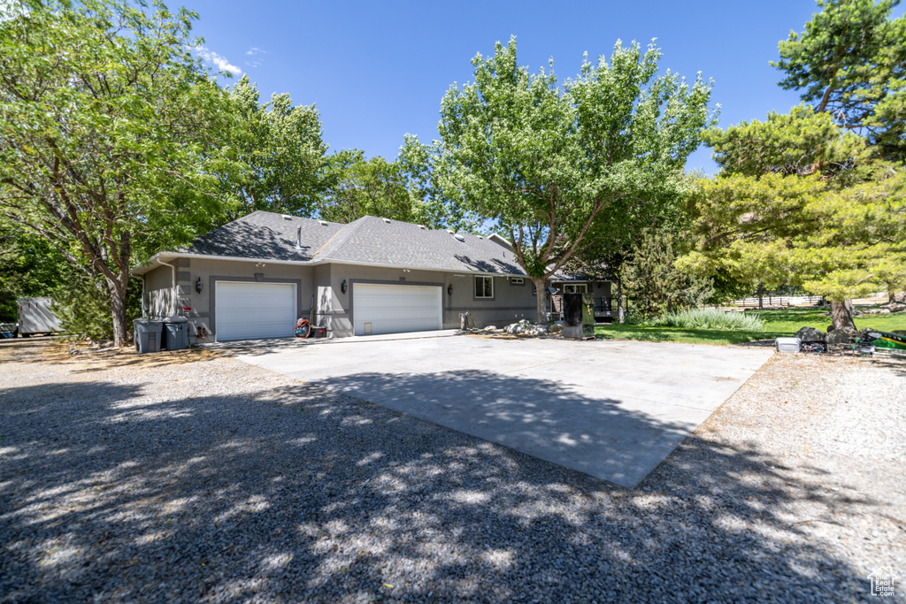 View of front facade with a garage, concrete driveway, and stucco siding