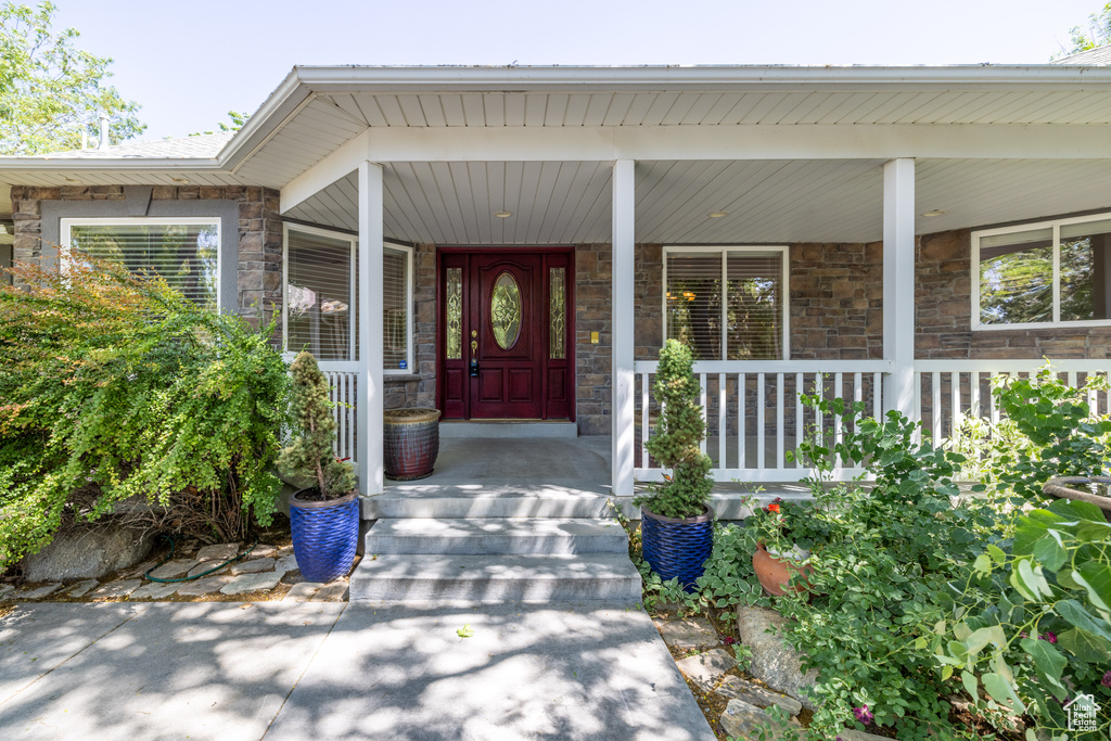 Property entrance with stone siding and a porch