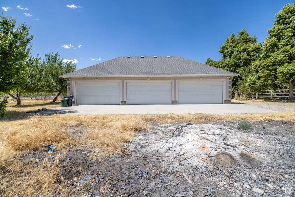 View of property exterior with a shingled roof and stucco siding