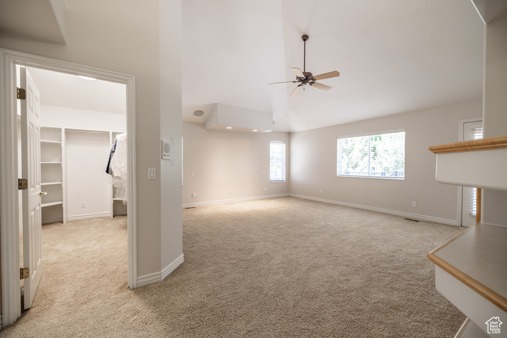 Unfurnished living room with ceiling fan and light colored carpet