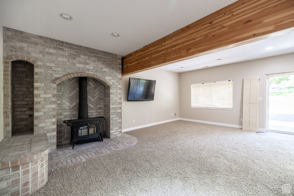 Unfurnished living room with a wood stove, carpet, and recessed lighting