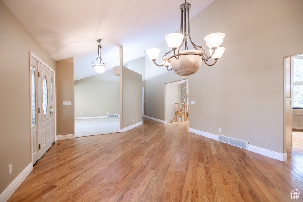 Foyer featuring a chandelier, light wood finished floors, and lofted ceiling