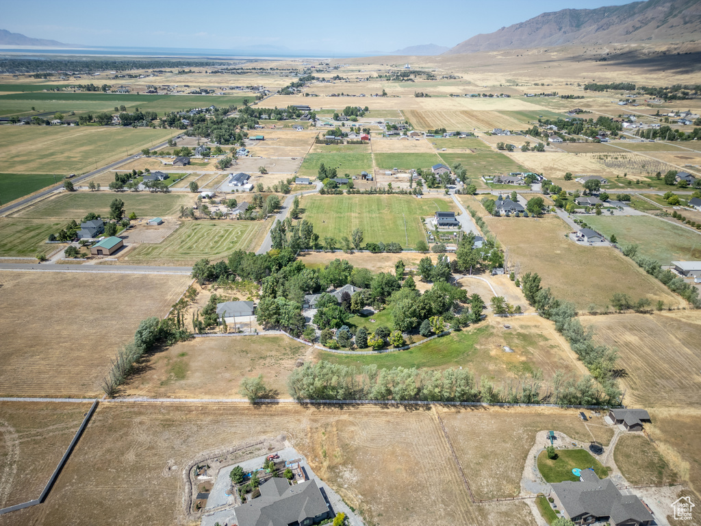 Aerial view of property and surrounding area featuring rural landscape and a mountain backdrop