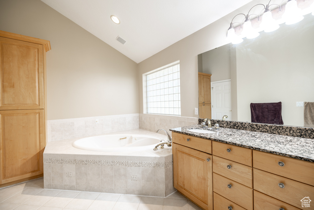 Bathroom featuring vanity, vaulted ceiling, a bath, tile patterned flooring, and recessed lighting