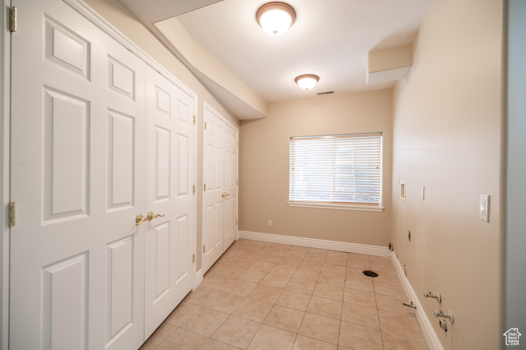 Unfurnished bedroom with light tile patterned floors and multiple closets