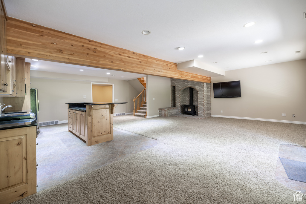 Kitchen featuring recessed lighting, dark countertops, open floor plan, freestanding refrigerator, and light brown cabinets