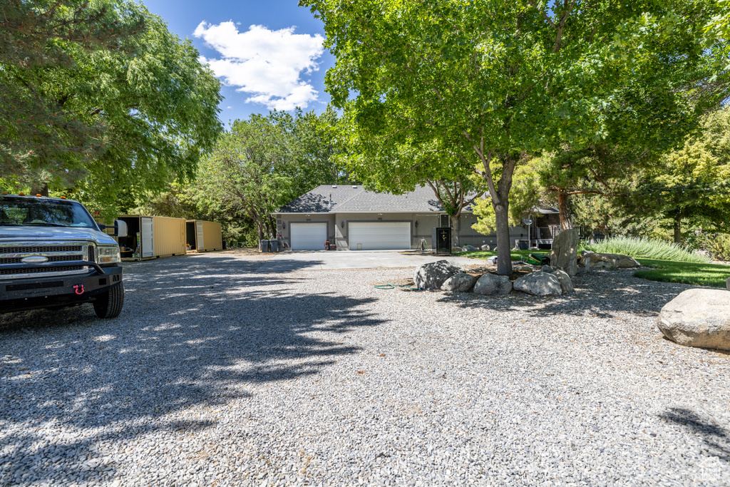 Obstructed view of property with gravel driveway and a garage