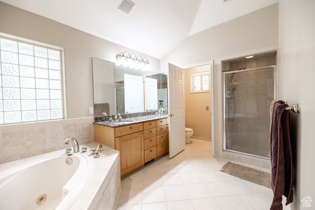 Full bathroom with a whirlpool tub, a stall shower, vanity, lofted ceiling, and tile patterned flooring