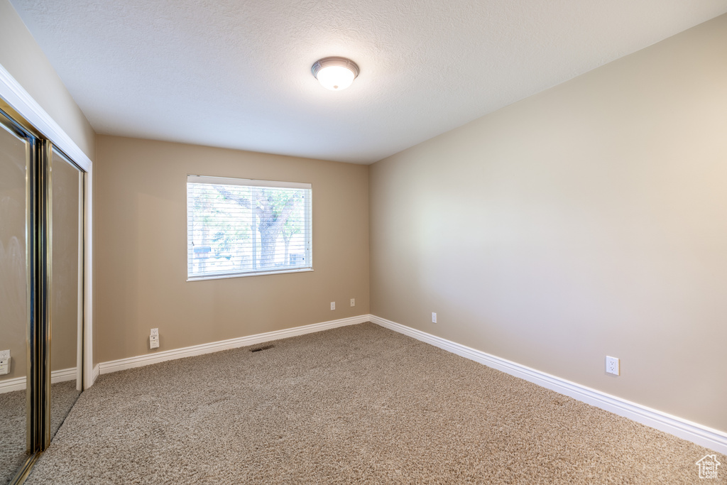 Unfurnished bedroom with carpet and a closet