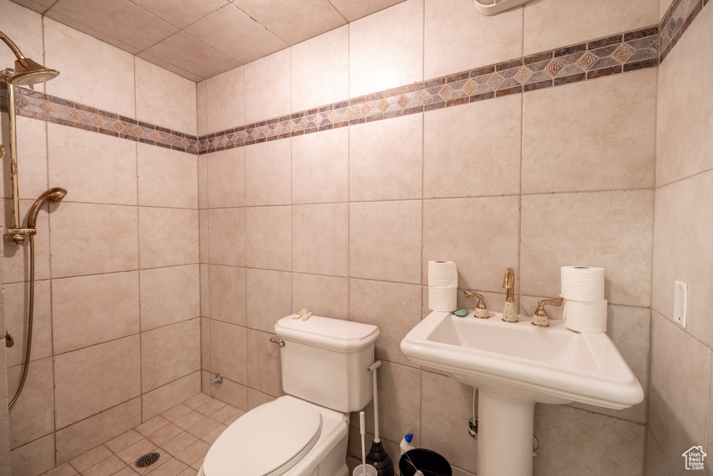 Bathroom featuring a shower stall and tile walls