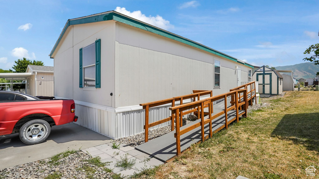 View of home\'s exterior featuring a shed and a yard
