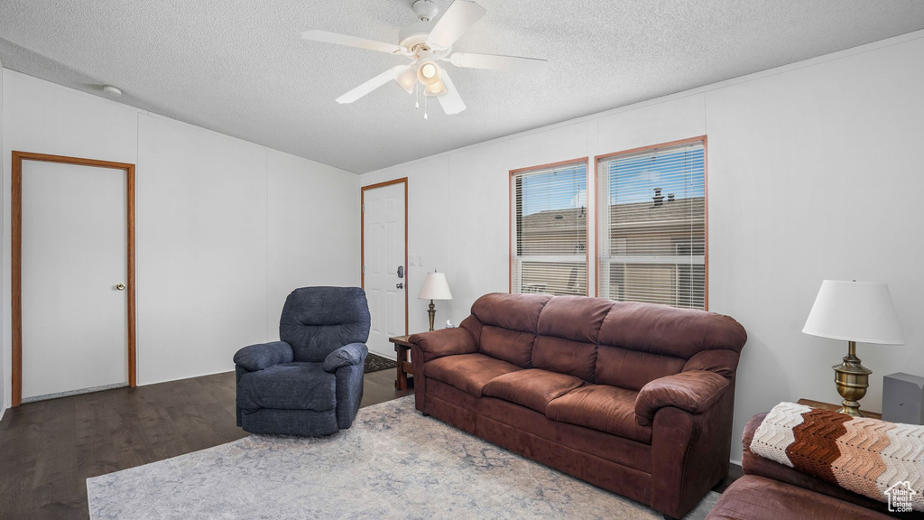 Living room with wood finished floors, a textured ceiling, and a ceiling fan