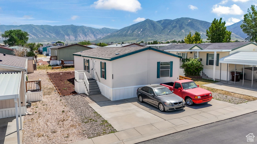 View of front facade with a mountain view and roof with shingles