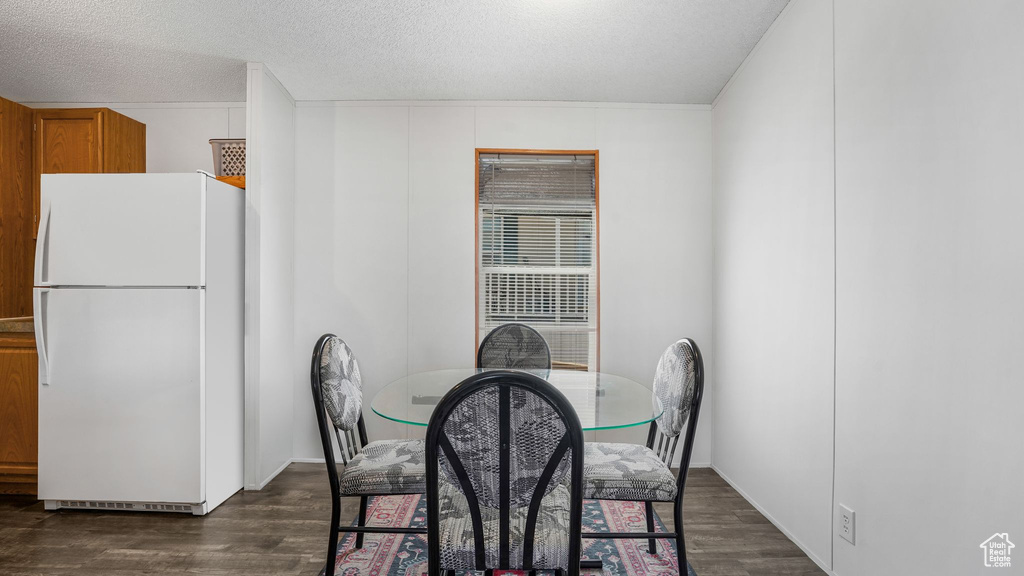 Dining area featuring dark wood-style floors and a textured ceiling