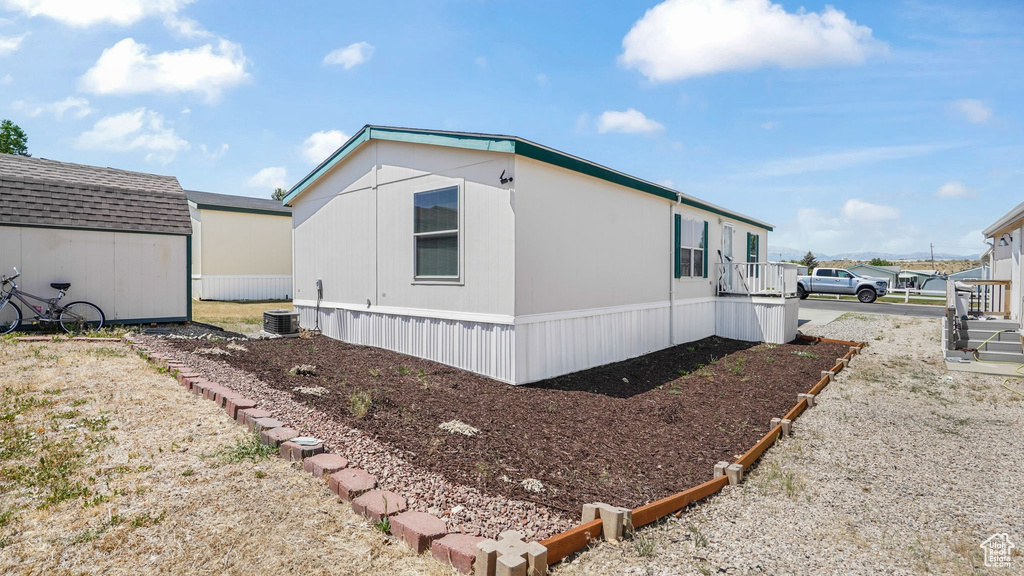 View of side of property with a shed