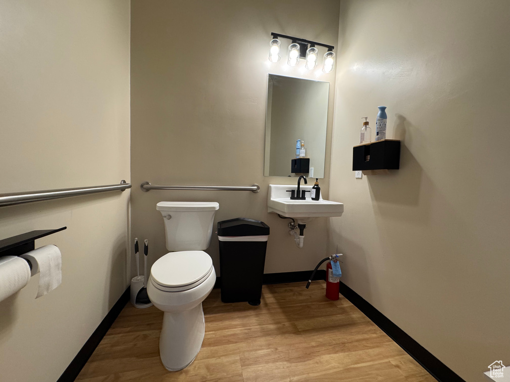 Bathroom with toilet and wood finished floors