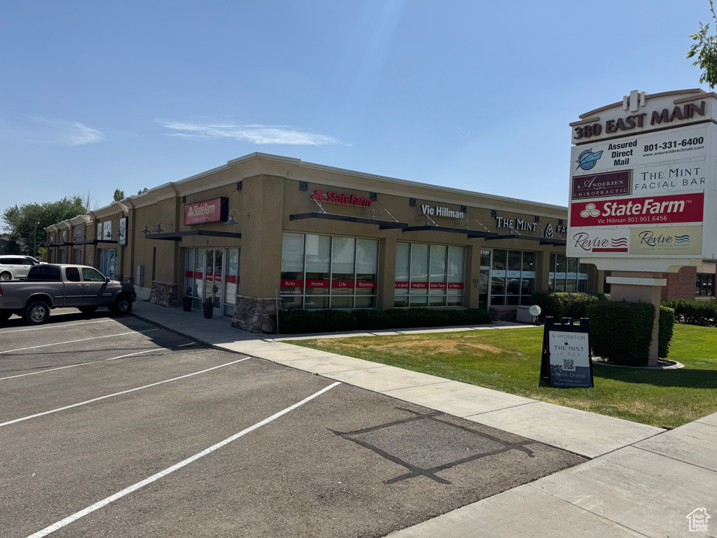 View of commercial property featuring uncovered parking