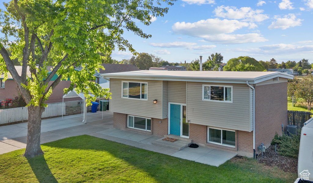 Bi-level home with a patio area, brick siding, and entry steps