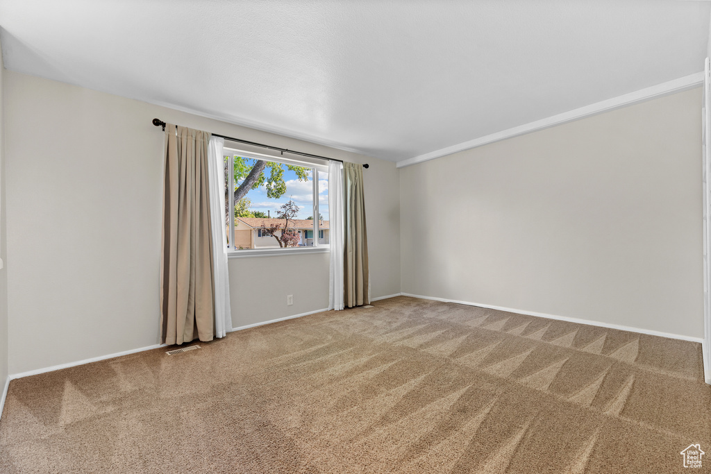 Carpeted empty room with baseboards