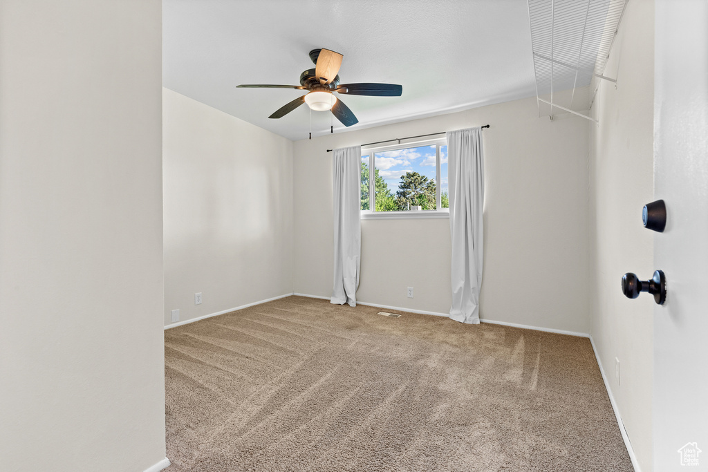 Empty room with carpet and a ceiling fan
