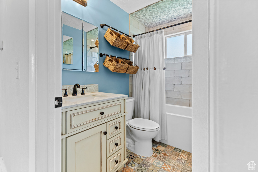 Full bathroom featuring vanity, shower / bathtub combination with curtain, and tile patterned flooring