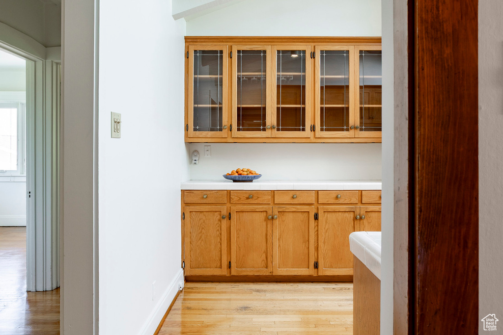 Bar area featuring light wood-style floors and baseboards