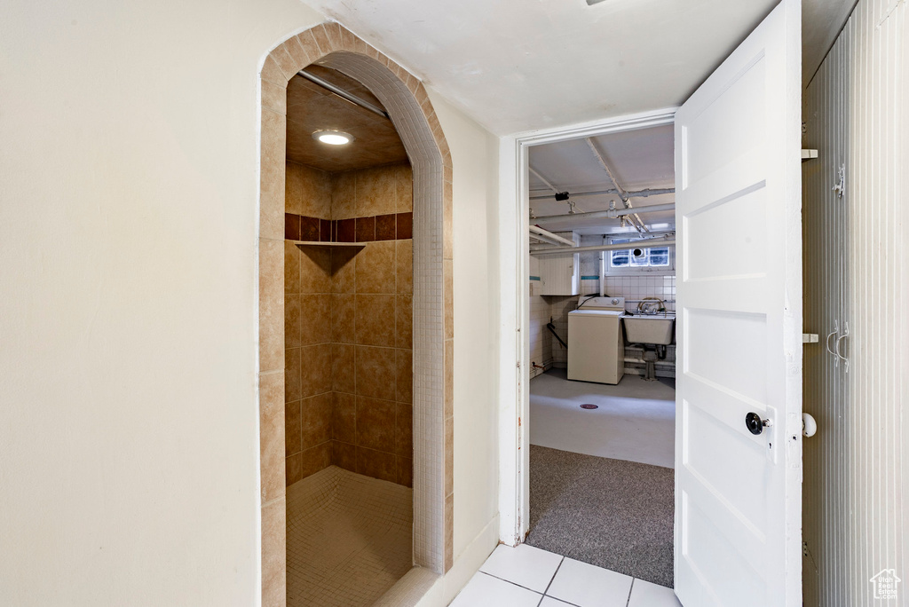 Bathroom featuring washer / clothes dryer, a stall shower, and tile patterned flooring
