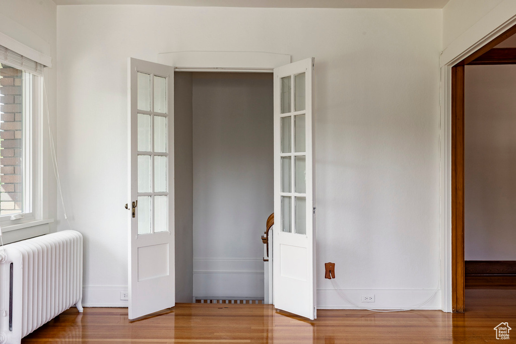 Foyer entrance with radiator, plenty of natural light, and wood finished floors